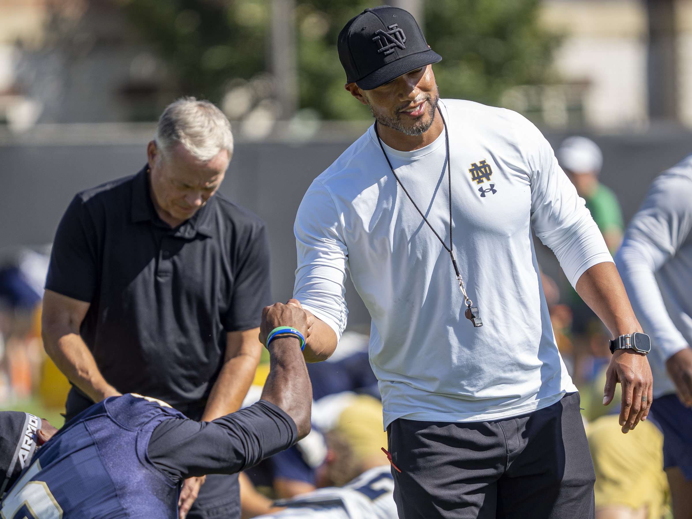 Notre Dame Football Head Coach Marcus Freeman bonds with players during stretch lines.
